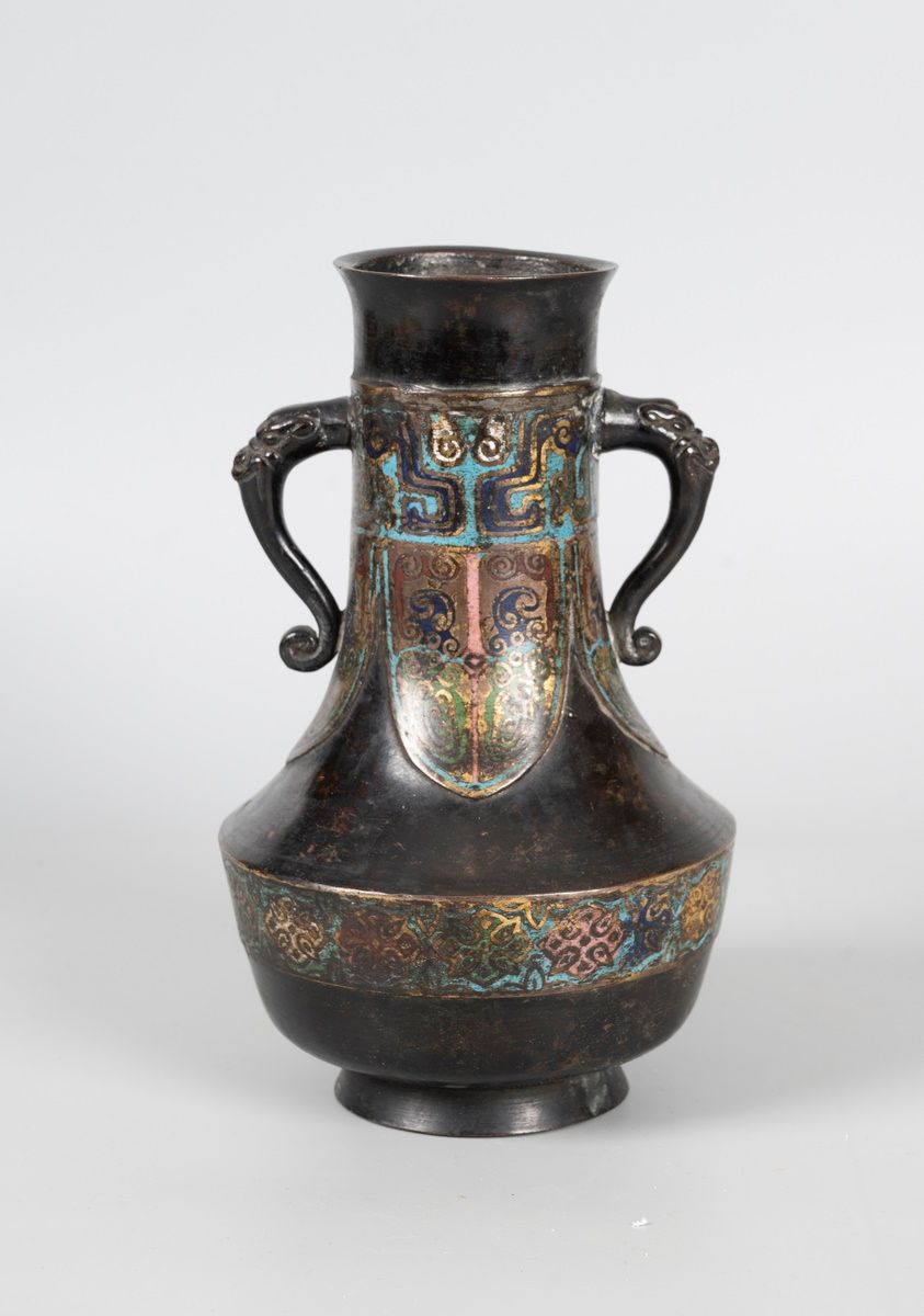 Null 中国

一个局部涂有棕榈叶和饕餮之眼的青铜花瓶。小鞋跟，奇美拉手柄。

19世纪。高25厘米

磨损的