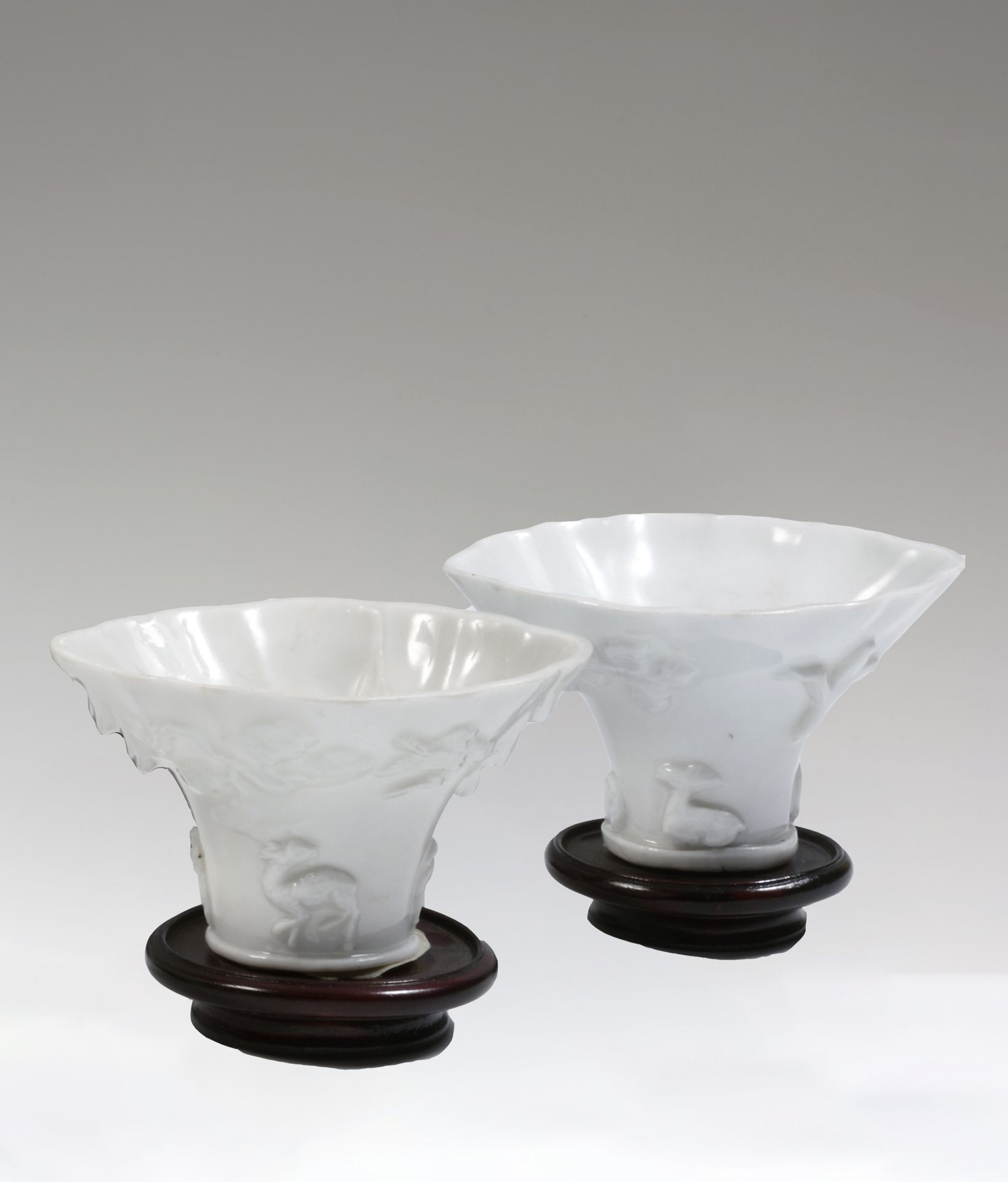 Null 
中国

两只角形白瓷酒杯，浮雕装饰有嵌合体、鹿、梅花、云和岩石。

康熙时期（1662-1722）。

H.6厘米，长10厘米。