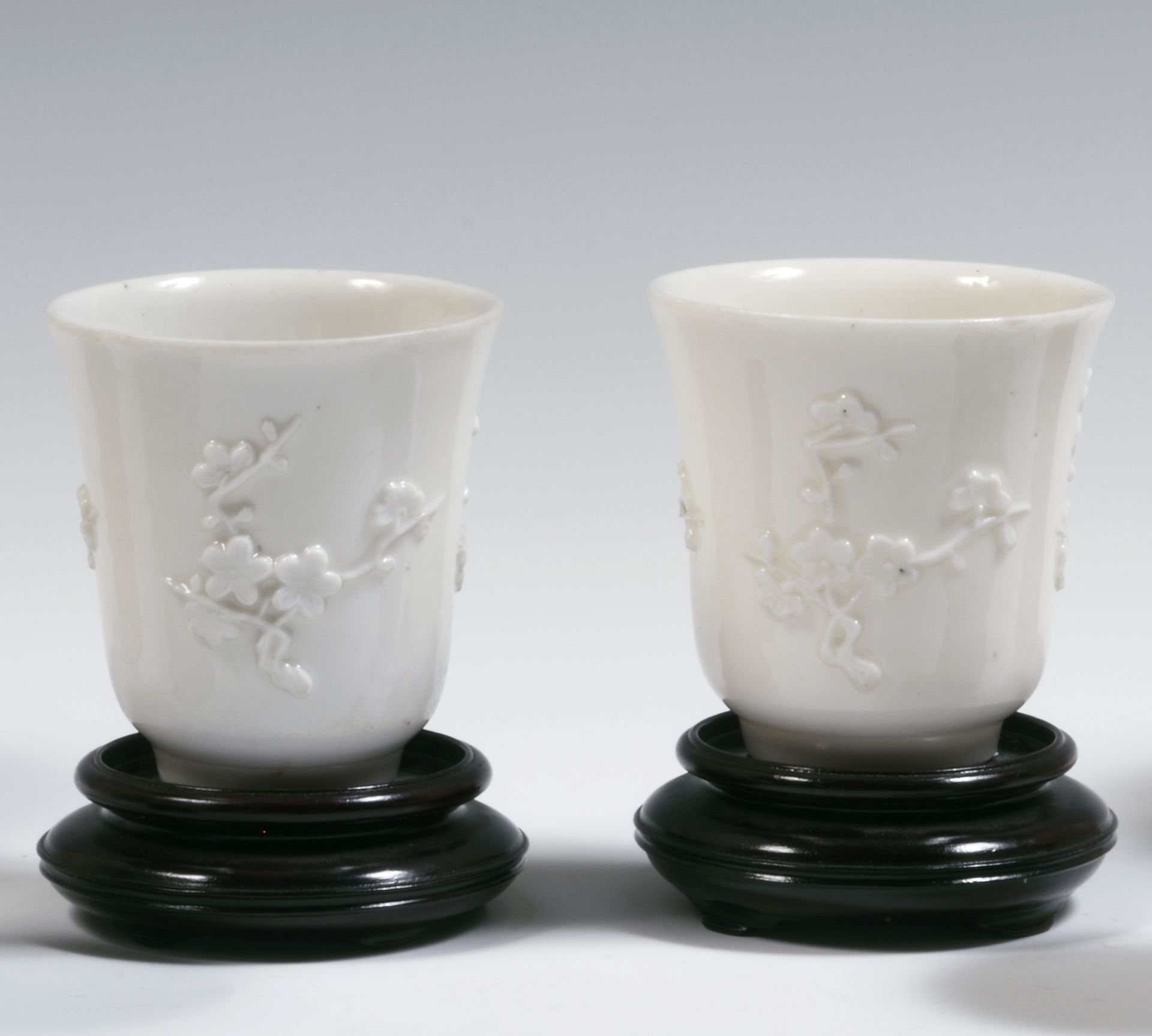 Null 
中国

两只中国白瓷杯，浮雕装饰有梅花树枝。

康熙时期（1662-1722）。

H.8厘米。

每个杯子的边缘有一个小缺口。