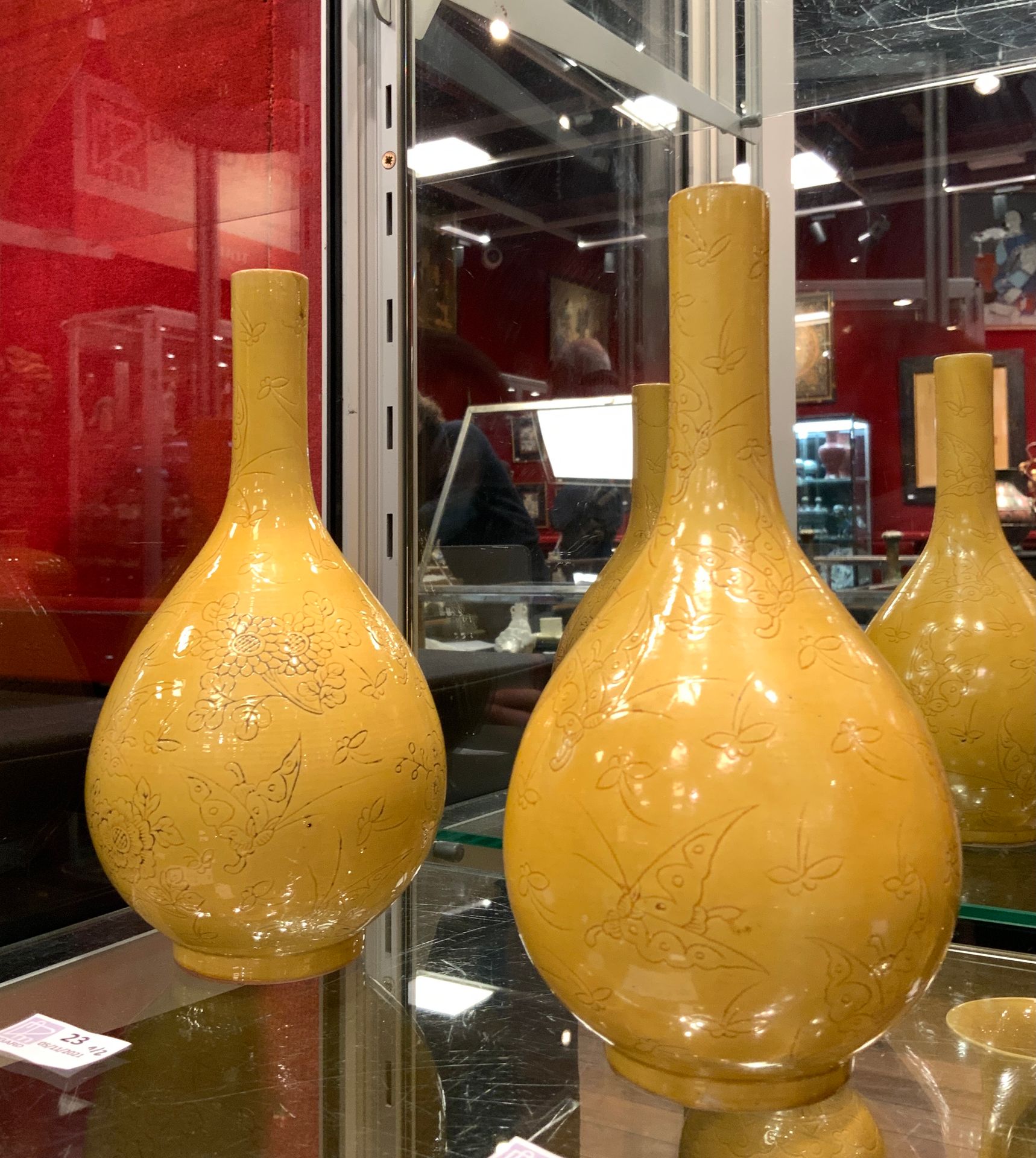 Null 
一对黄釉瓷瓶，刻有蝴蝶和花朵的装饰。底座上有康熙朝的开光印记

中国，晚清时期。

H.23.5厘米。

(恢复到一个人的脖子)