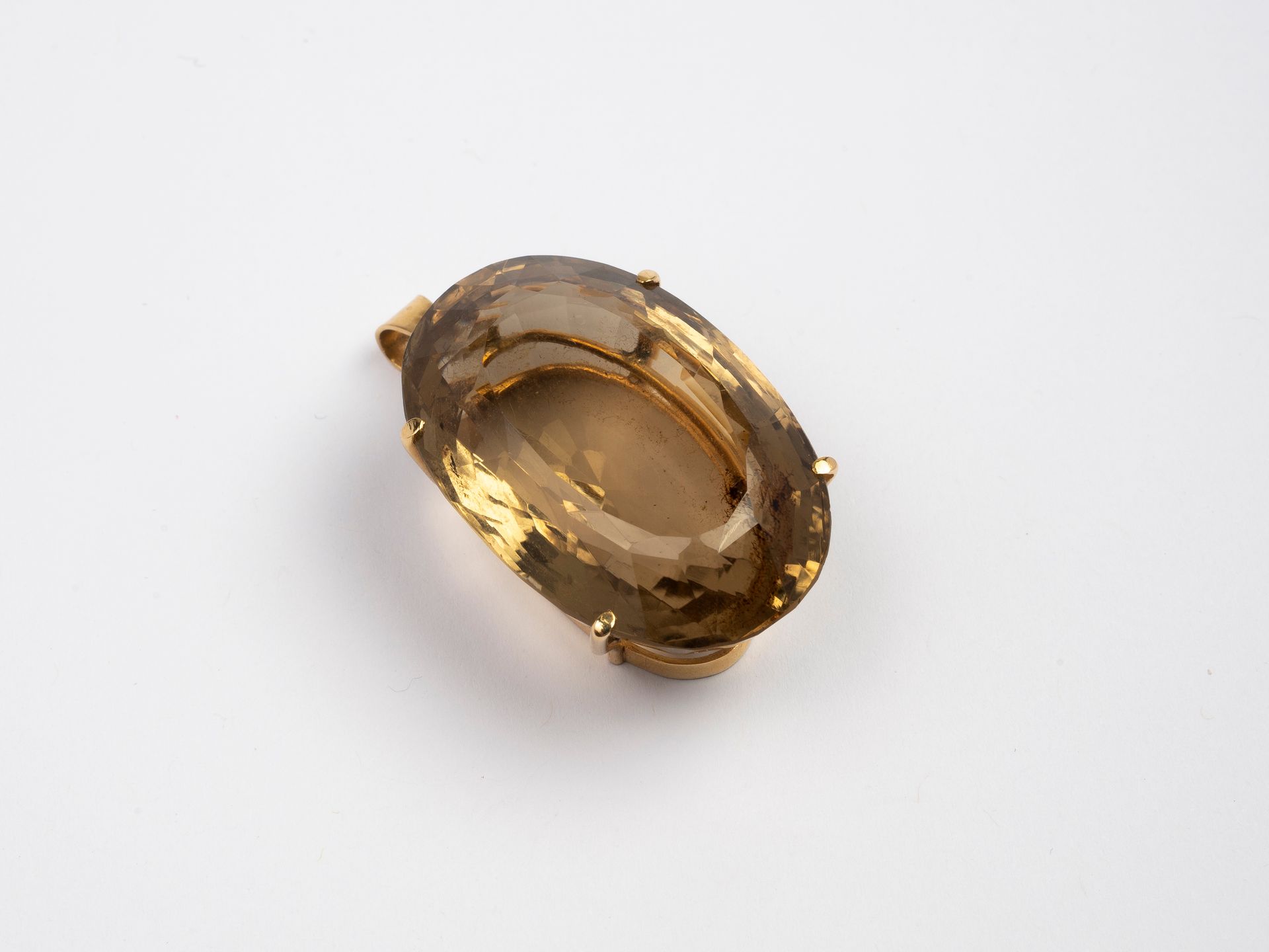 Null Ciondolo in oro 750°/°°° decorato con un grande quarzo fumé ovale.

Peso lo&hellip;
