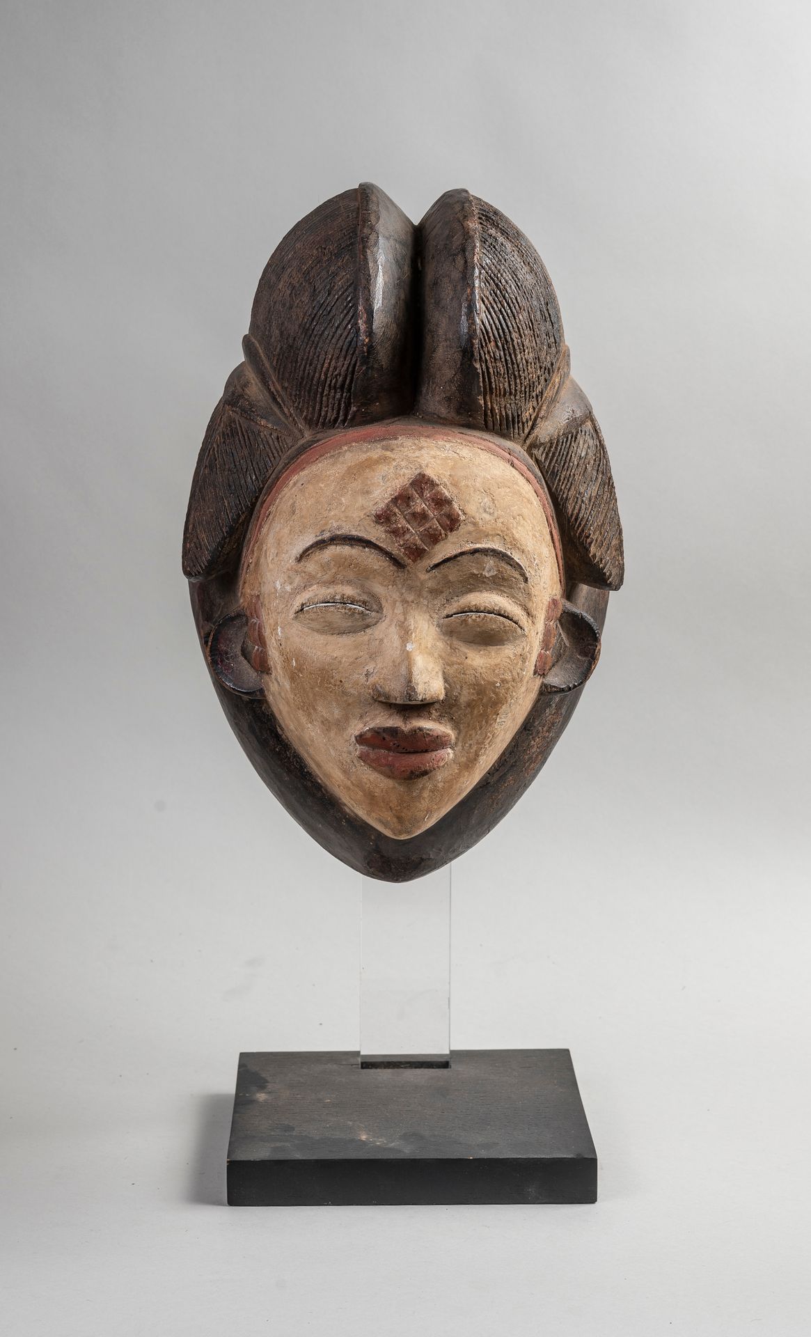 Null 
PUNU-Maske aus geschnitztem, polychromem Holz. H.33 cm.