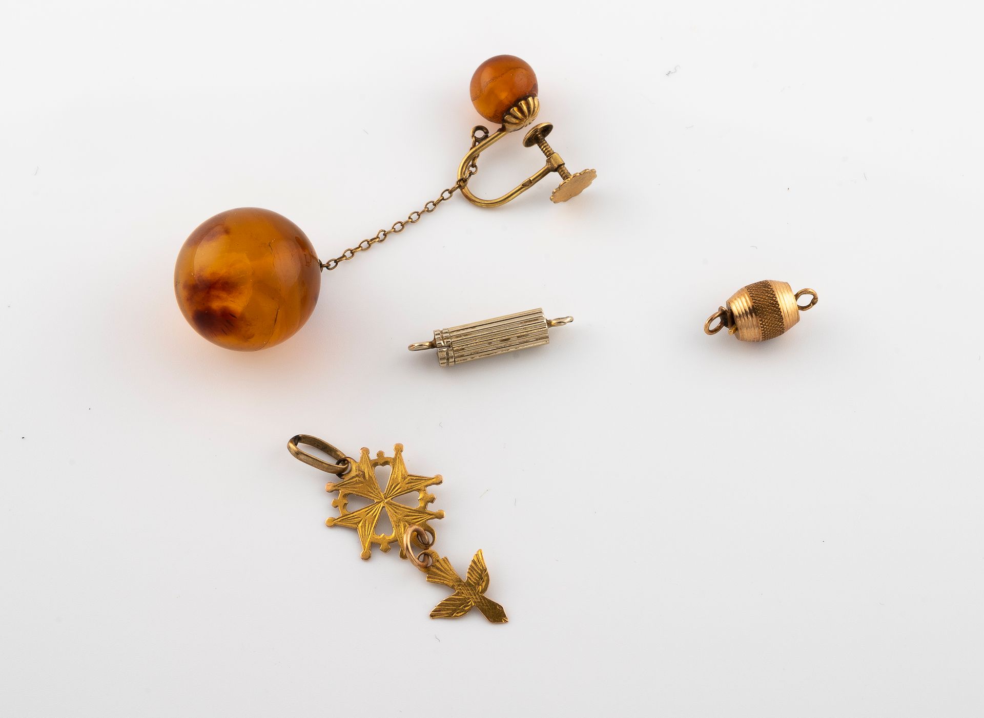 Null 750°/°黄金拍品，包括两个扣子，吊坠Saint Esprit，耳环与琥珀。
毛重：6,2克。