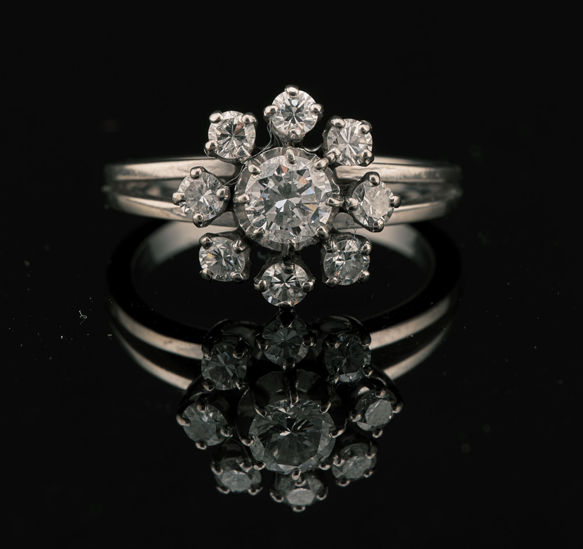 Null 18K白金雏菊戒指（鹰头标志），镶嵌有一颗中央钻石（直径5.01毫米），周围有八颗钻石（均无荧光）。法国大师的标记。TDD 55.PB : 5,13g