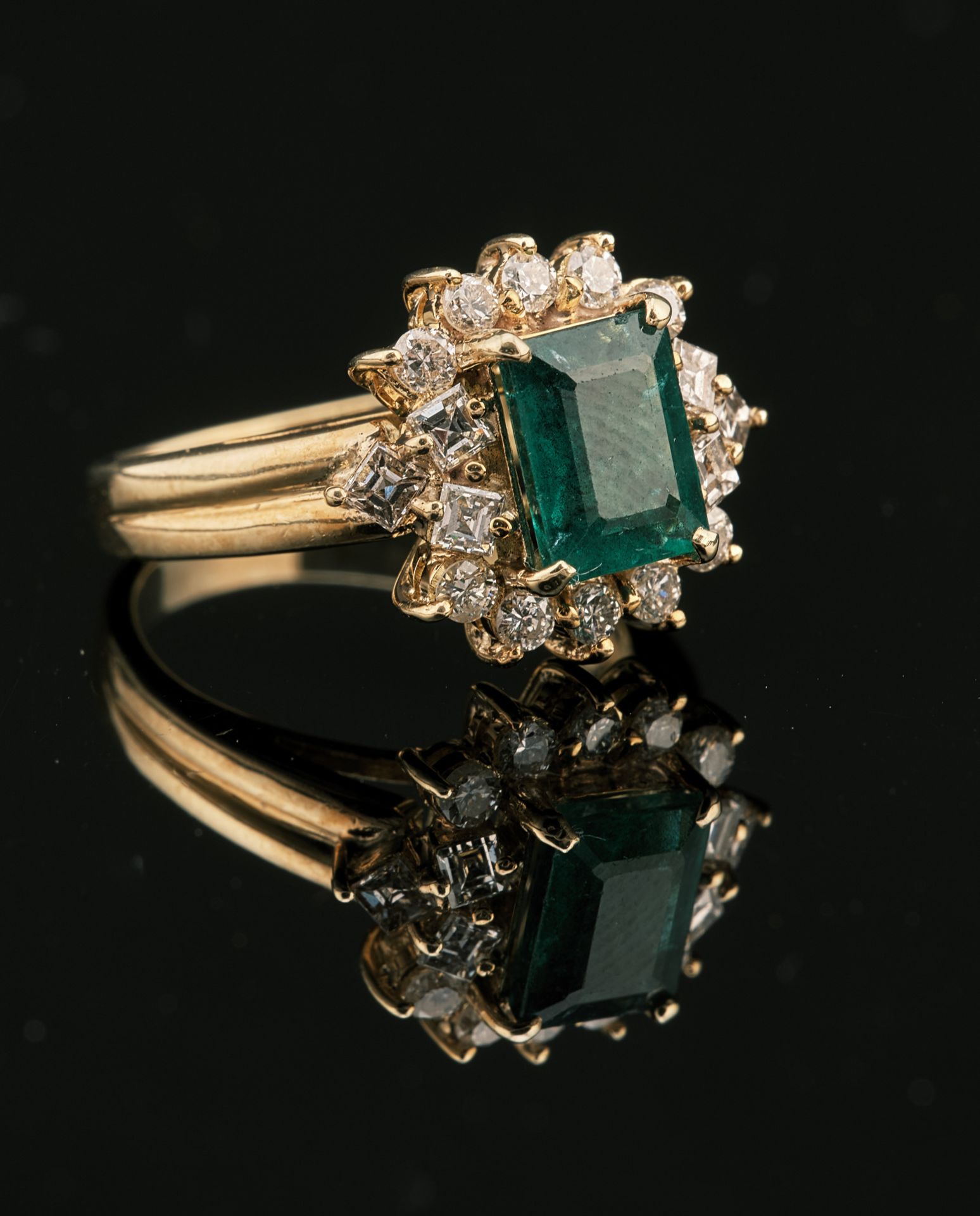 Null 黄金18K 750千分之一的戒指，装饰有一颗持续大小约为1.5克拉的绿色祖母绿，周围有一排10颗现代大小的钻石，肩部有6颗公主大小的钻石，全部采用爪式&hellip;
