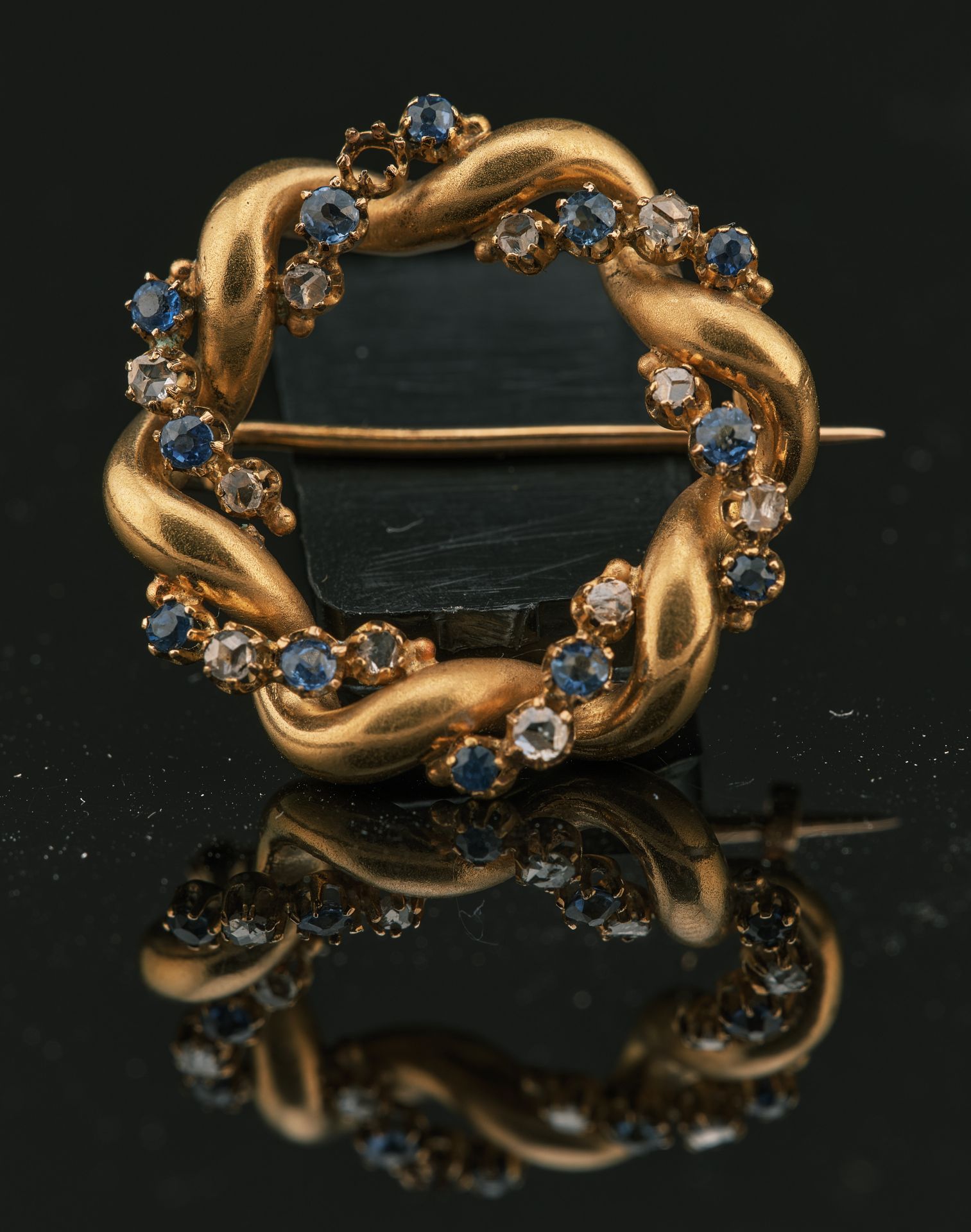 Null 迷人的18K黄金750千分之一的胸针，扭曲的圆形，装饰有玫瑰切割钻石和蓝色宝石，全部采用爪式镶嵌（缺少一颗宝石）

有编号484的针脚和海军C级锚的打&hellip;