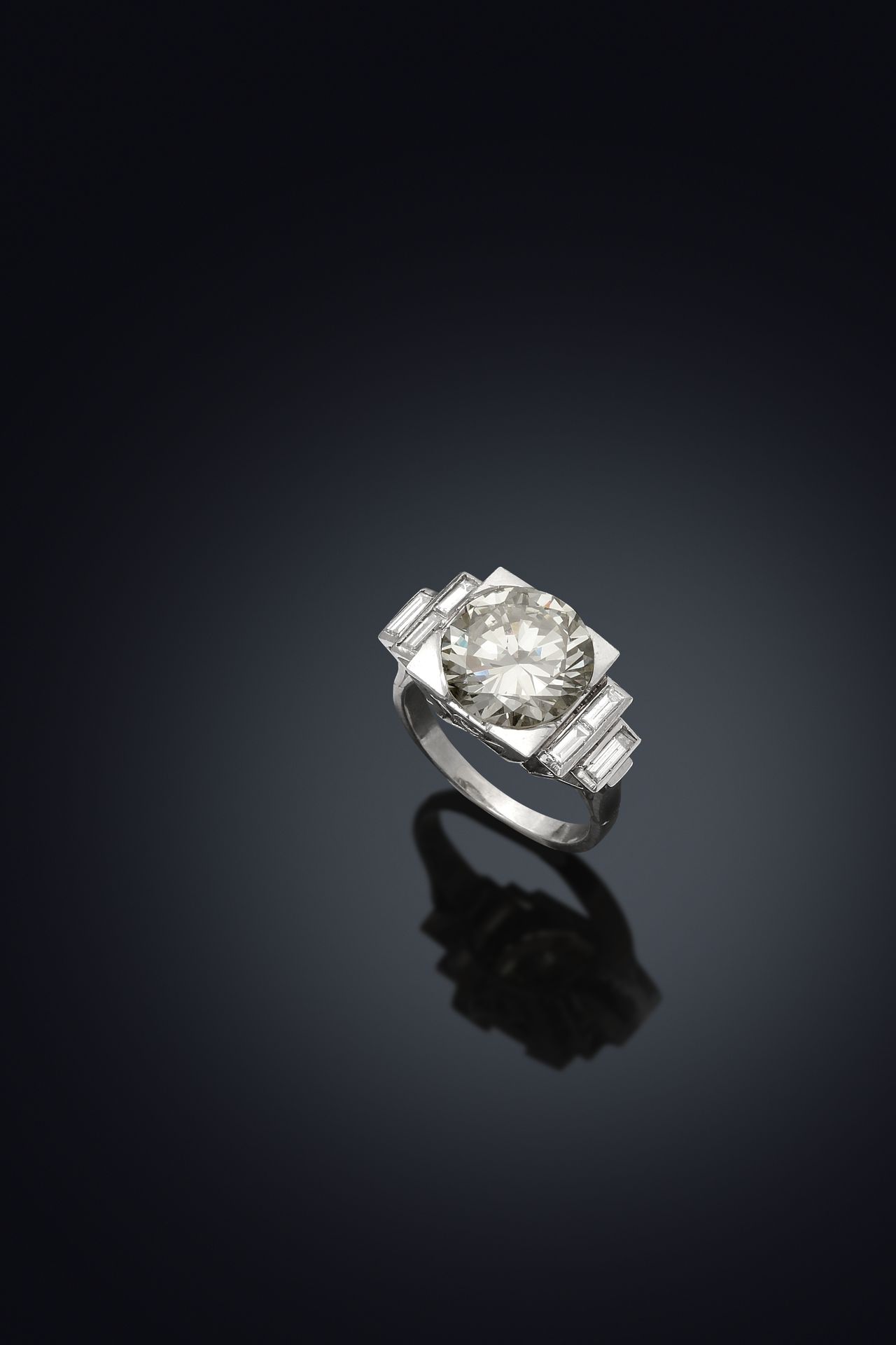 Null 铂金95万分之一的装饰艺术戒指，装饰有一颗4.58克拉的现代切割钻石，采用爪式镶嵌，由6颗长方形切割钻石支撑，采用轨道式镶嵌，采用几何形的镂空镶嵌。
&hellip;