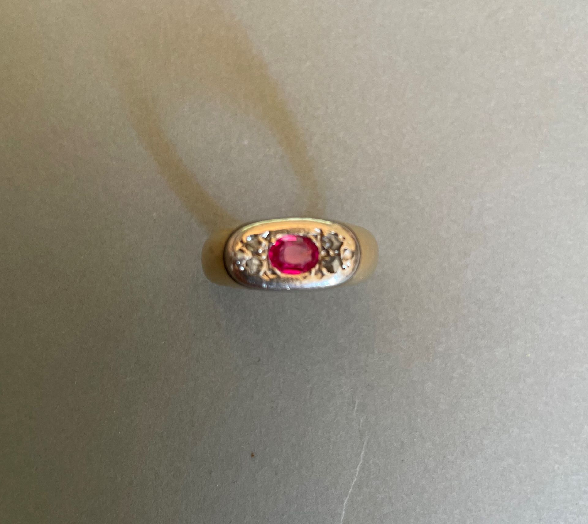 Null 戒指上镶嵌着一颗椭圆形的合成红宝石，中间是两三颗呈三角形排列的玫瑰式切割钻石。

黄金和铂金镶嵌。

重量：9,2克。