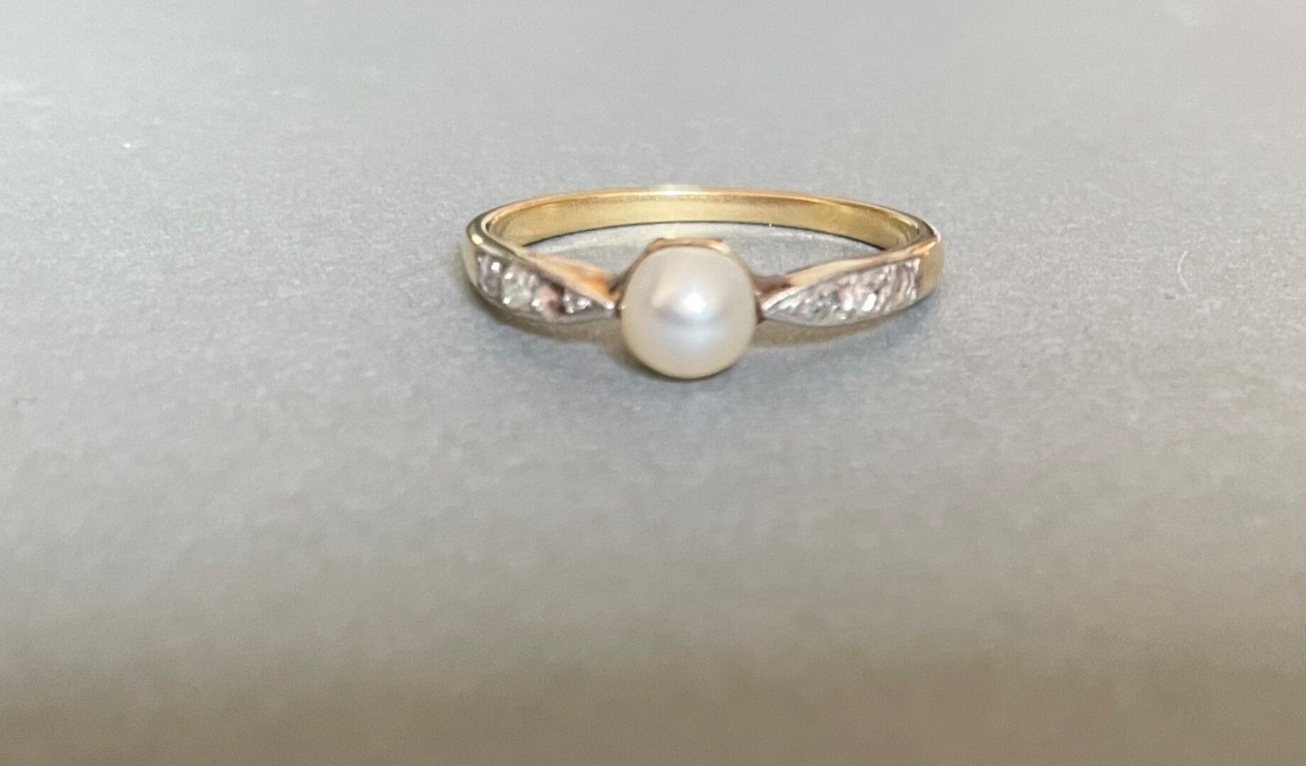 Null 黄金戒指，在两行三颗珍珠之间镶嵌了一颗可能是精美的纽扣珍珠

玫瑰式切割钻石。

(Mq. 1)

重量：2,1克。