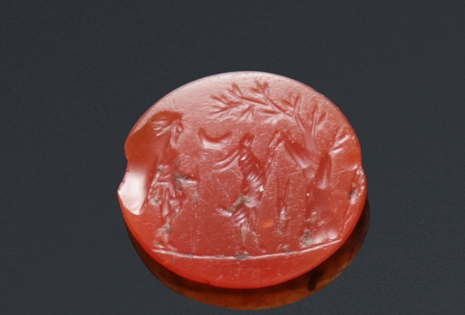 Null 平坦的椭圆形凹版上刻着一个人和一只山羊，靠着右边的一棵树站着。红玉髓。

罗马艺术，2世纪。

1,3 x 1,5厘米。

芯片。