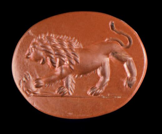 Null 扁椭圆凹刻一狮传左，戏蟹。红碧玉。
，田野里，一个字母T。罗马艺术，2世纪。
1 x 1.4 cm