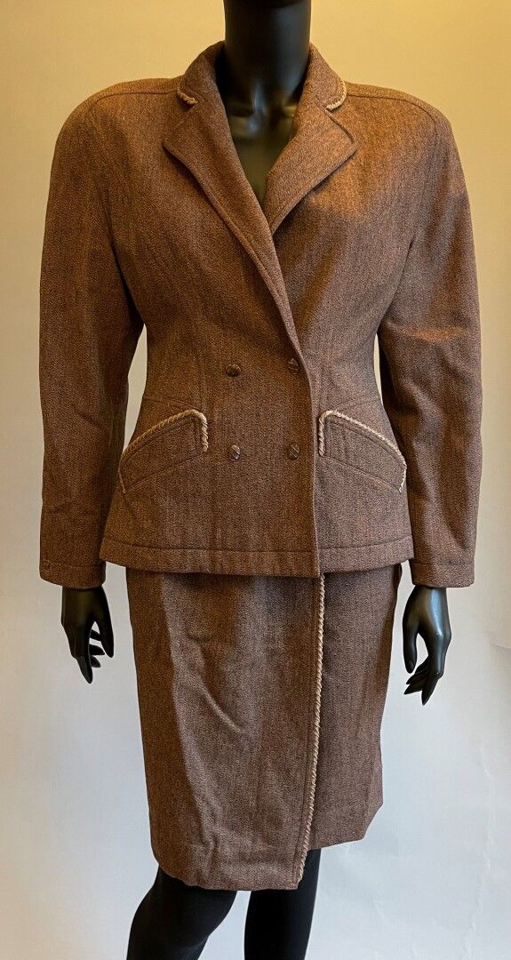 Null Thierry MUGLER

棕色羊毛套装，配以浅棕色的丝绸应用，包括

长袖上衣，缺口领，双纽扣，带压钉，口袋

和一条带夹子扣的高腰裹身裙。

&hellip;