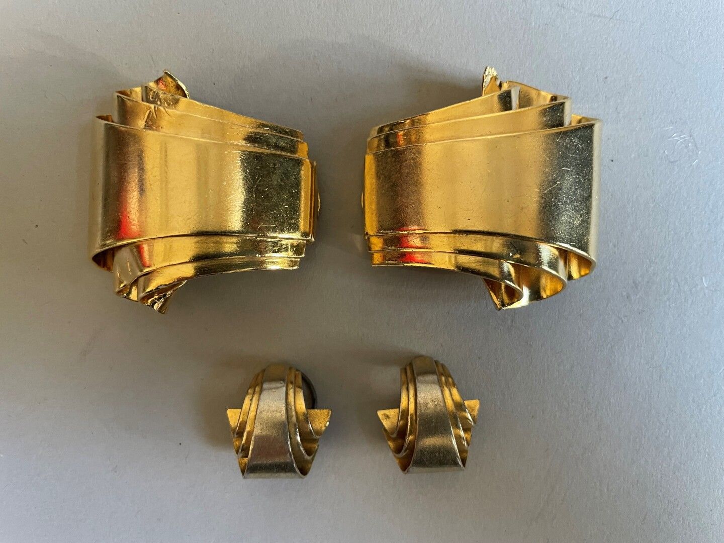 Null 匿名的装饰艺术作品

鎏金金属卷轴的一半，包括一对耳夹

和一对衣襟夹。

一个扣子损坏