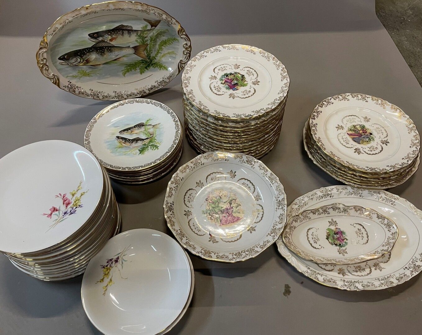 Null 瓷器晚餐服务的三个部分，装饰有鱼、日本字和花，包括餐盘、盘子、汤盘和一些碗。

(2例)