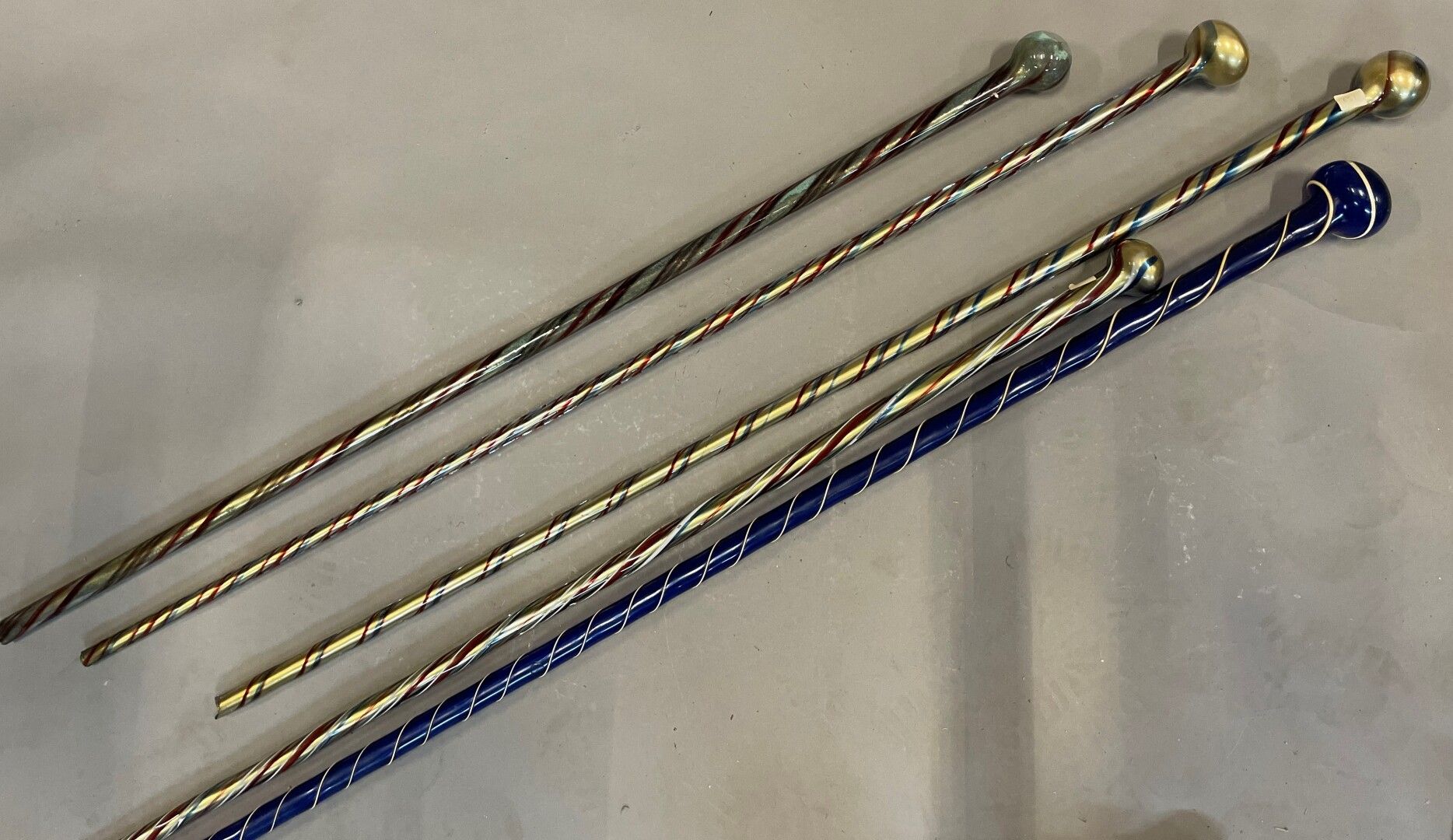 Null 五个多色和金色的纺纱玻璃手杖，有圆形的旋钮。

威尼斯，20世纪初

高：163、110、106、100和99厘米

损坏的末端。