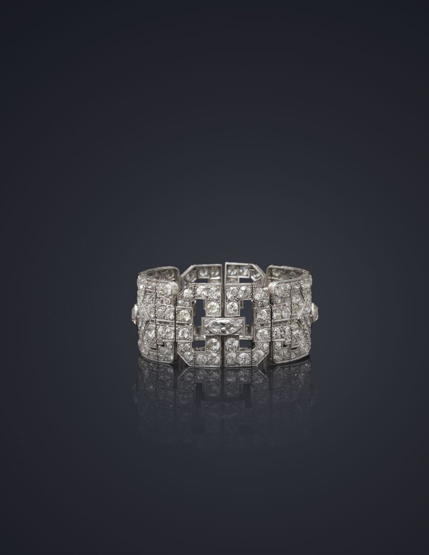 Null 20世纪30年代的重要铰链式手镯，由四个镂空的几何图案组成，围绕着两颗略带枕形切割的钻石和两颗较大的舟形切割钻石的老式切割钻石线条。 
铂金镶嵌，白金&hellip;