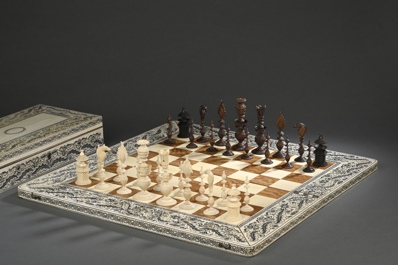 Null 一套 32 件的红木和象牙雕刻象棋。檀香木和象牙贴面的棋盘和棋盒上有雕刻的叶片装饰。
印度维扎加帕塔姆，19 世纪。
毛重：7317 克。
重量：23&hellip;