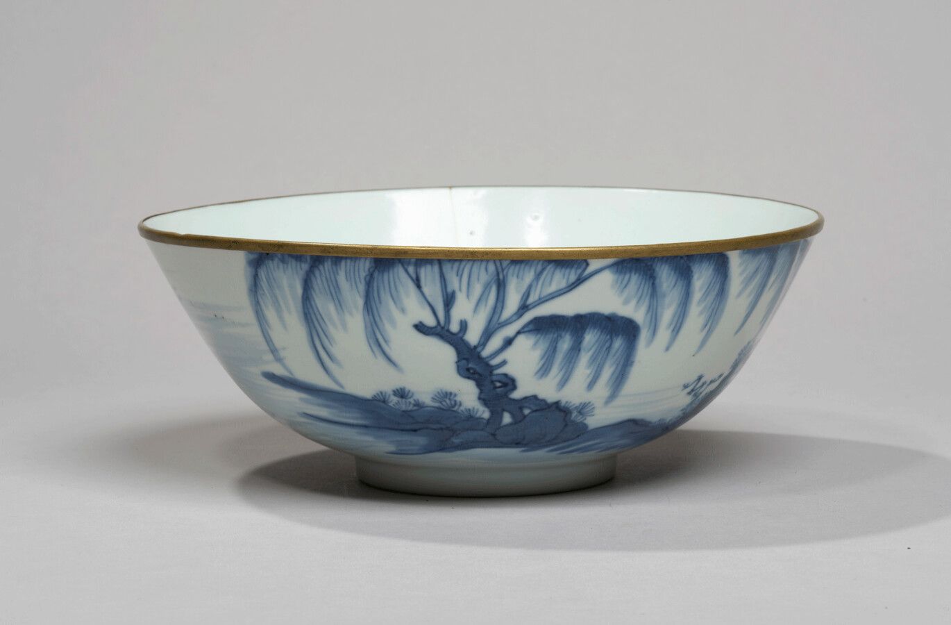 VIETNAM - XIXe siècle - 釉下青花瓷碗，饰以柳树附近的渔夫在他的舢板上。金属环状边缘。(Crack)
Diam. 17,5 cm.