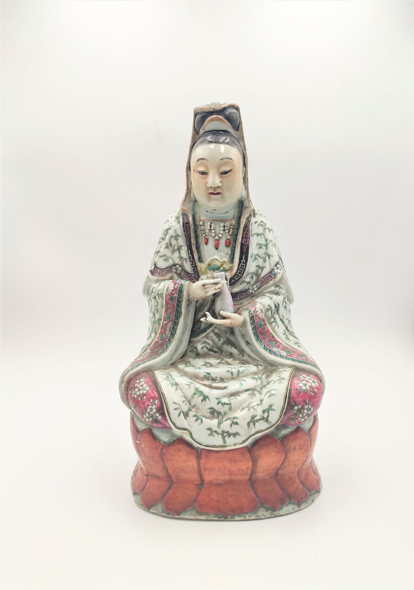 CHINE - XIXe siècle 
Guanyne en porcelaine à décor d'émaux polychromes tenant un&hellip;