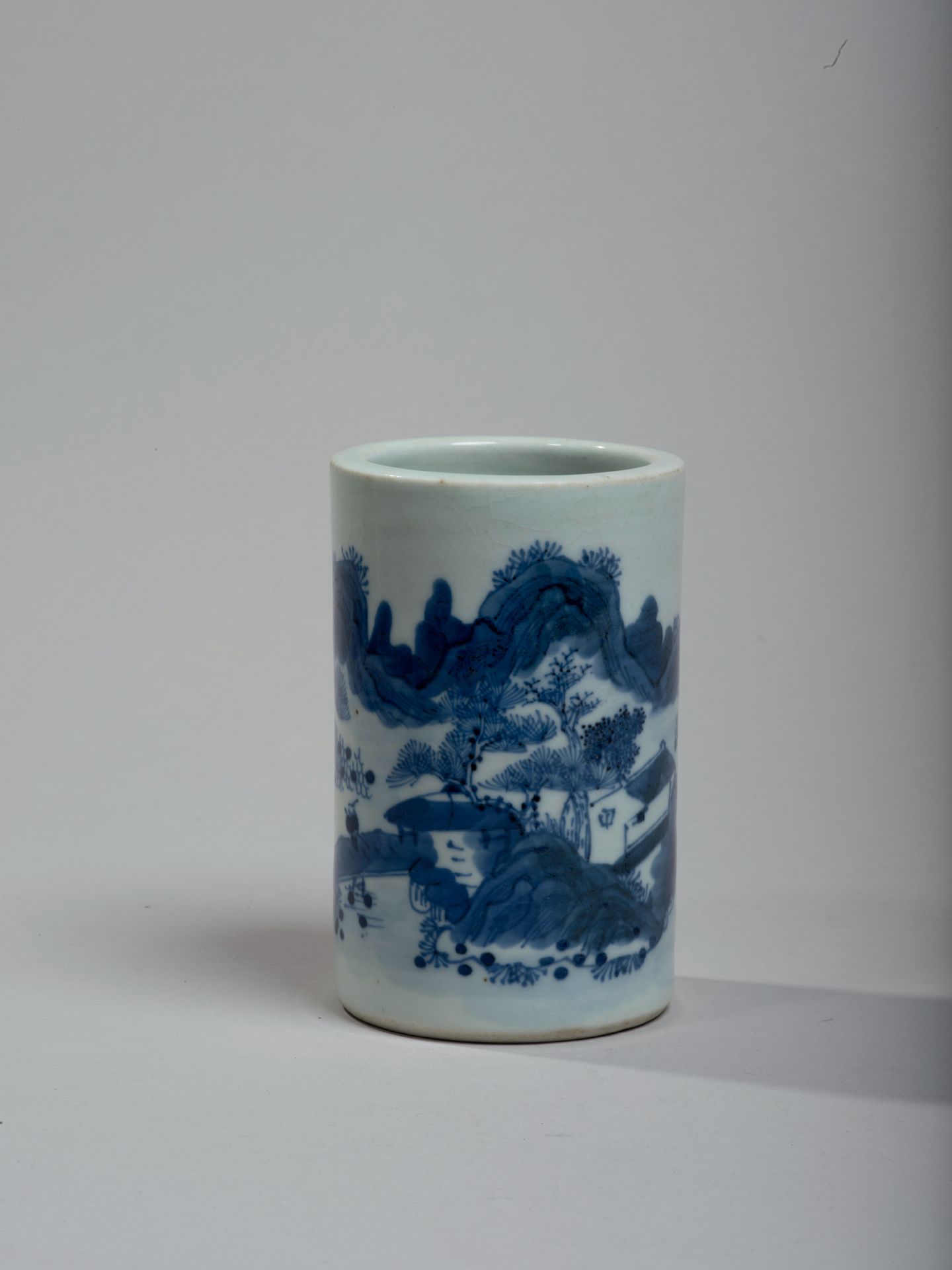 CHINE - XIXe siècle 
瓷器笔筒，蓝色釉下彩装饰的丘陵风景。高11厘米。