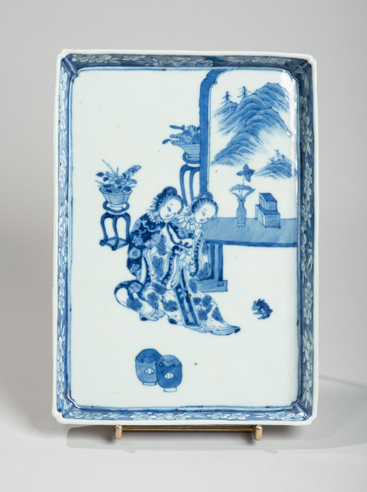 VIETNAM, Hue - XIXe siècle 
长方形瓷盘，釉下蓝色装饰，两个年轻女子在屏风旁看兔子，边框有花。
Dim. 25,5 x 18 cm.