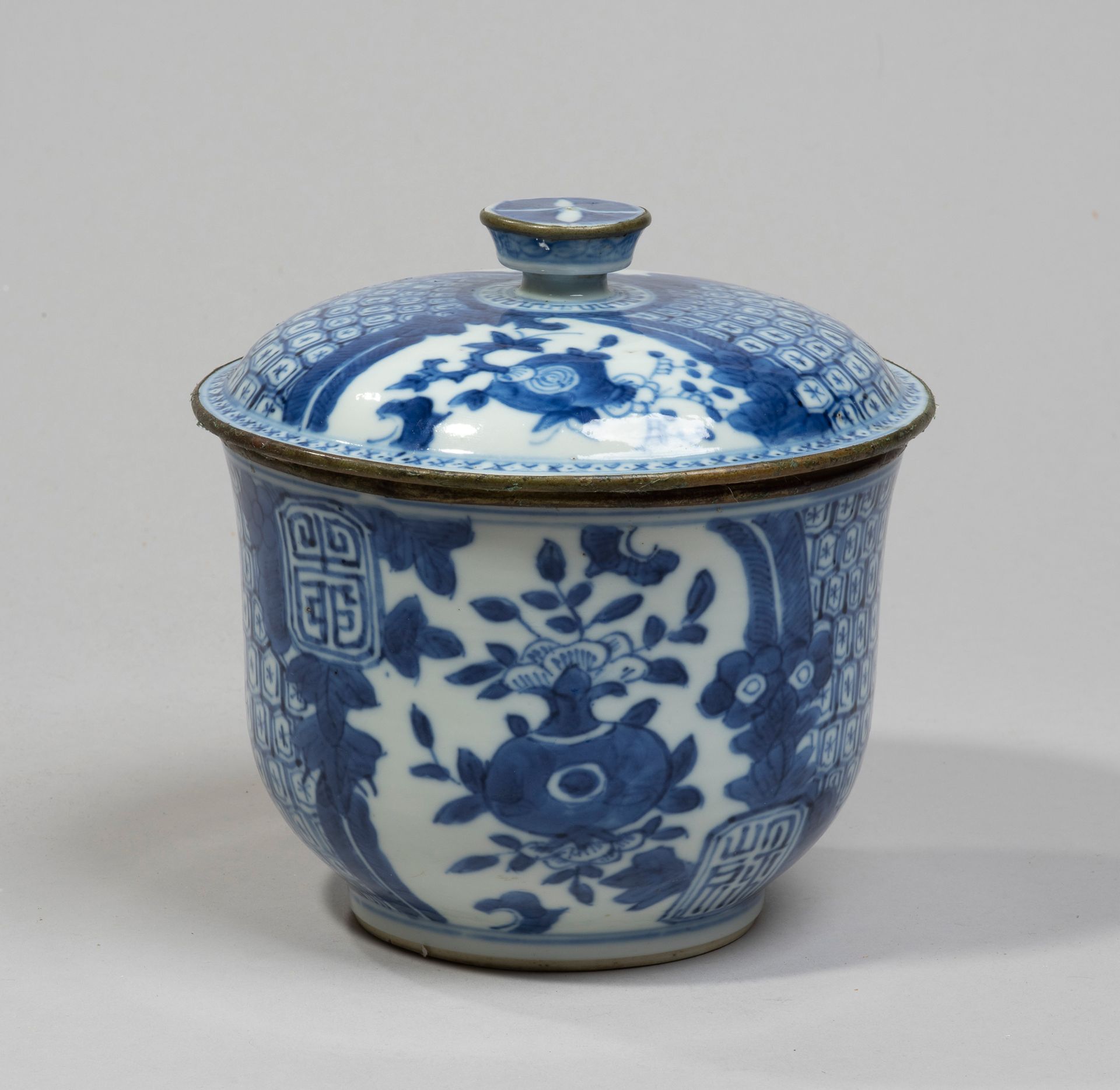 VIETNAM, Hue - XIXe siècle - 瓷器盖碗，以蓝色釉下彩装饰石榴、叶子和蜂巢图案。边缘用金属包围着。背面有Noi标记。
，高14厘米。