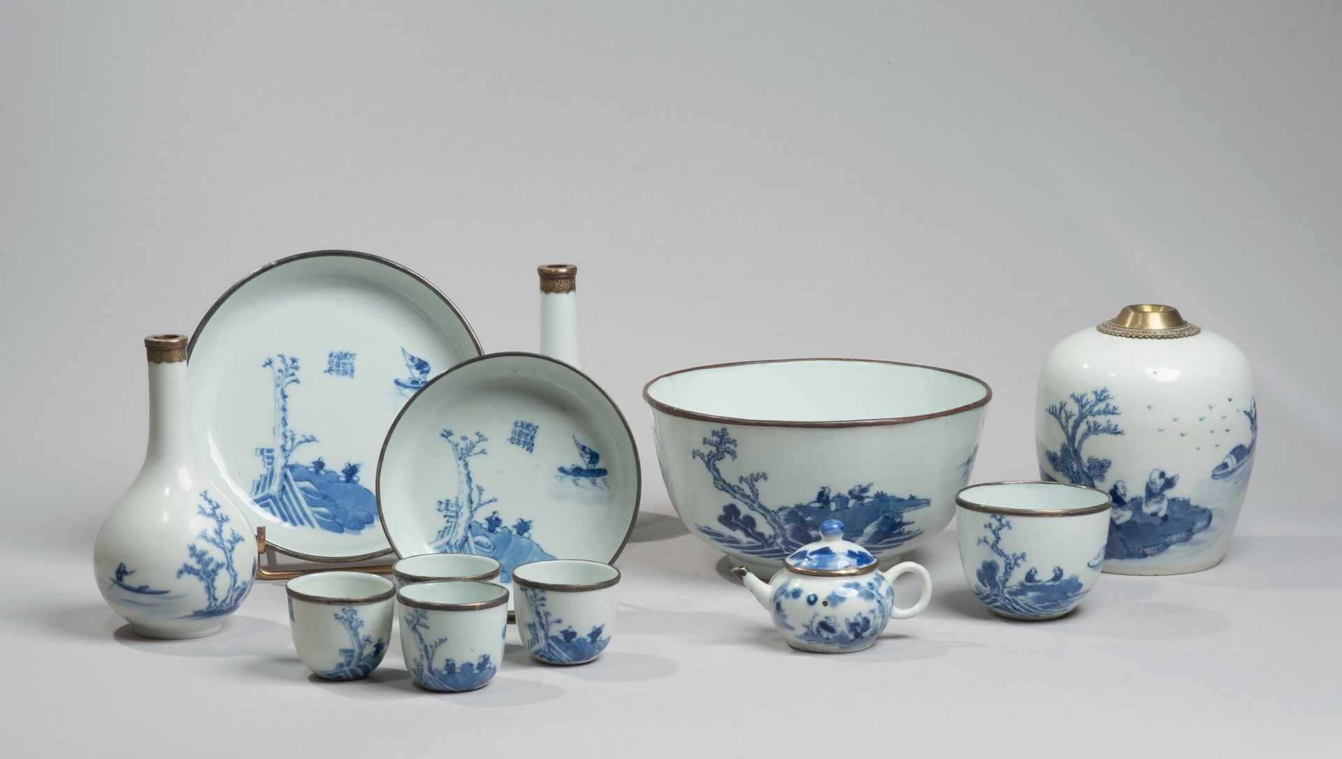 VIETNAM, Hue - XIXe siècle 
一套十二件的瓷器茶具，包括一个壶，两个碗，两个花瓶，一个茶壶和五个雪糕，以蓝色釉下彩装饰，两个学者在河边&hellip;