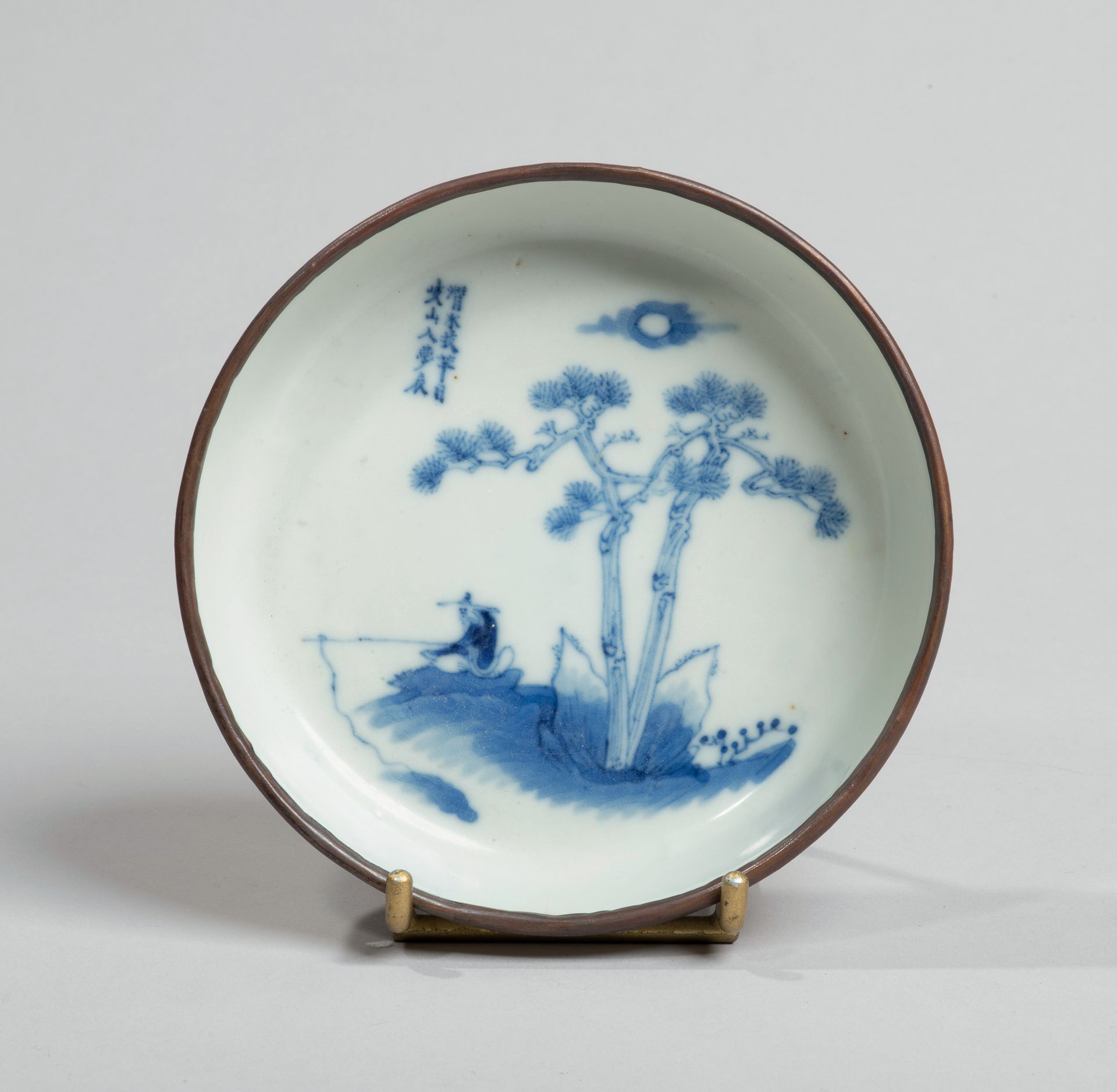 VIETNAM, Hue - XIXe siècle - 瓷盘，蓝色釉下彩装饰，松树下的渔夫。金属环状边缘。在背面，有Noi phú（内务部）的标记。(下面有裂&hellip;