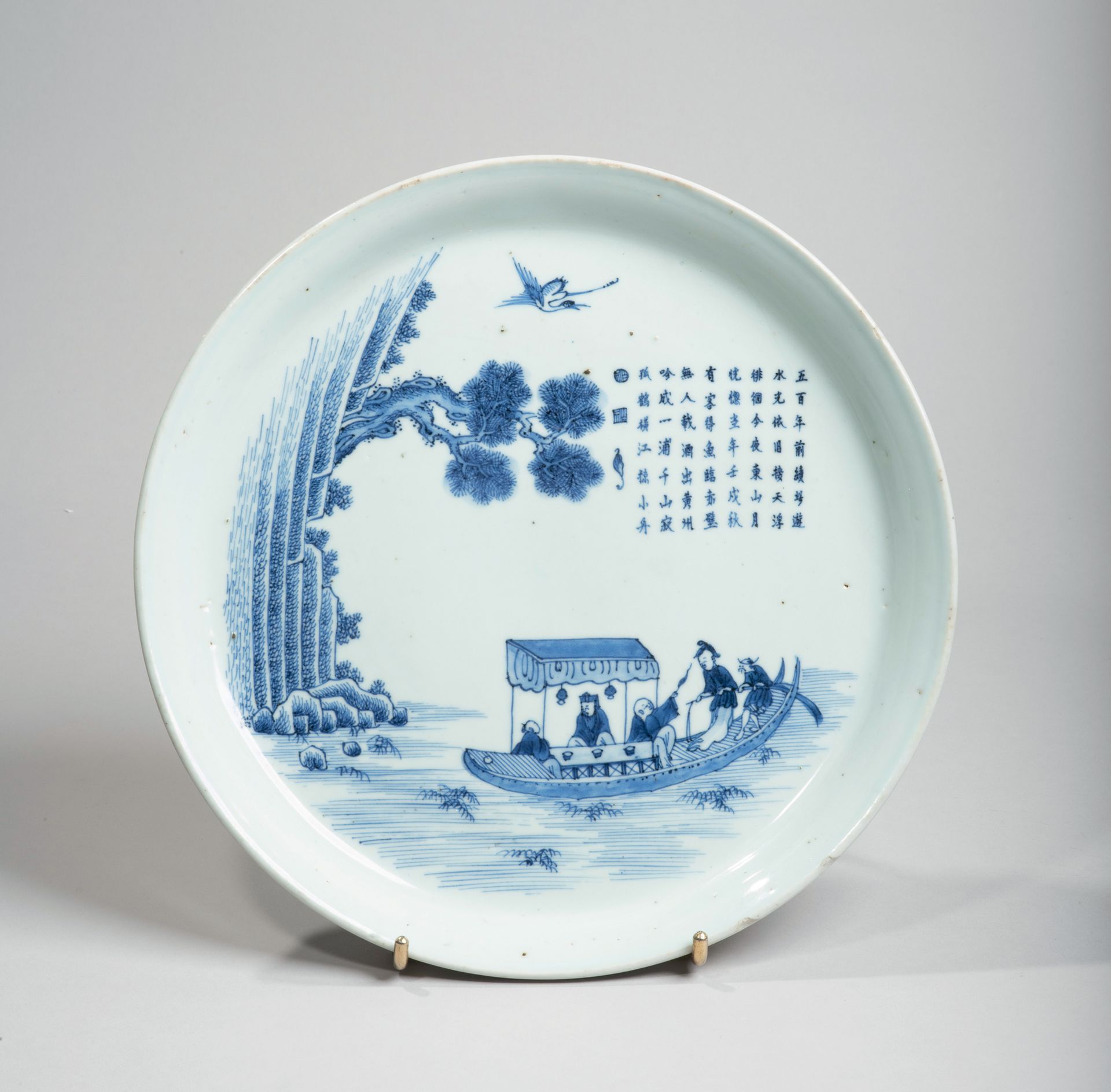VIETNAM - XIXe siècle 
瓷盘，釉下青花饰有学者在悬崖附近的船上，一只仙鹤在他们头上飞翔。芯片）直径26.5厘米