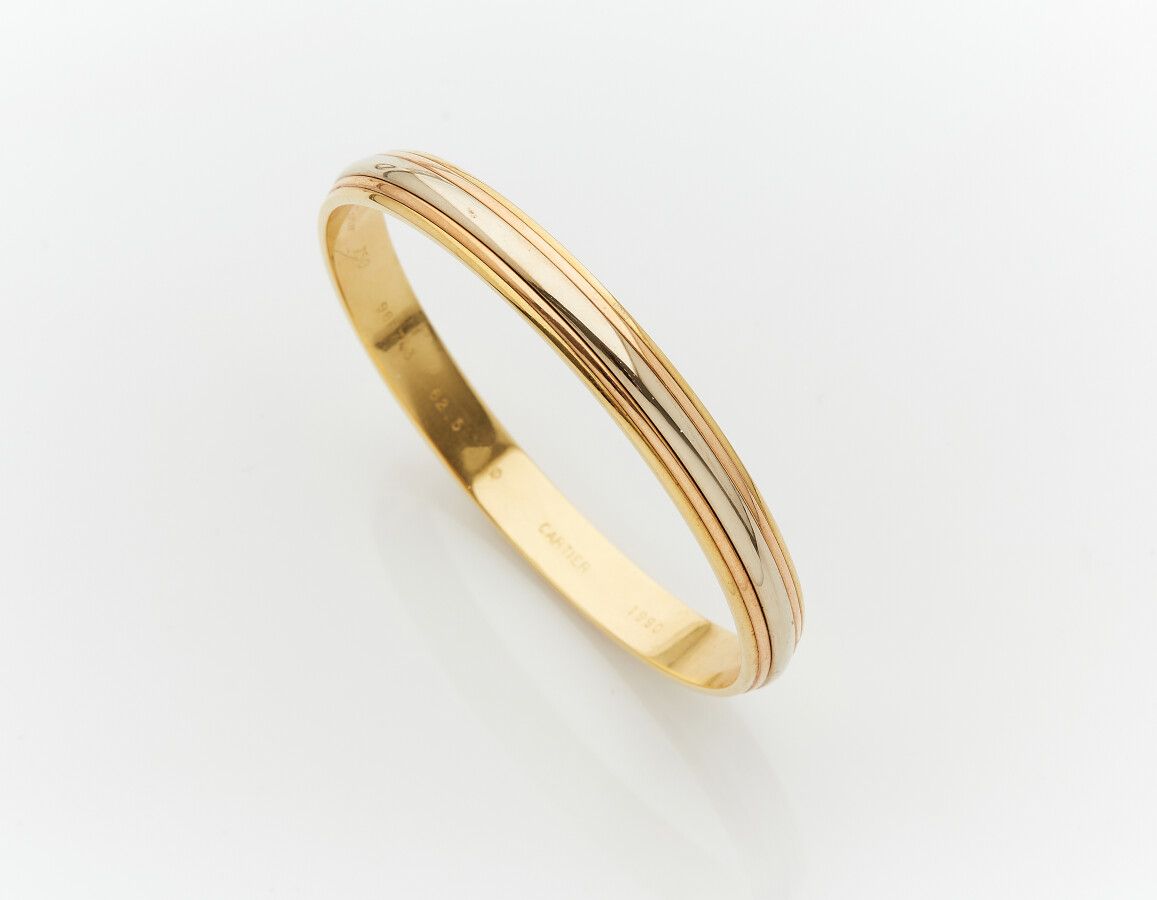 Null CARTIER

Rigid three-gold (750) BRACELET.

Signed CARTIER, dated 1990 and n&hellip;