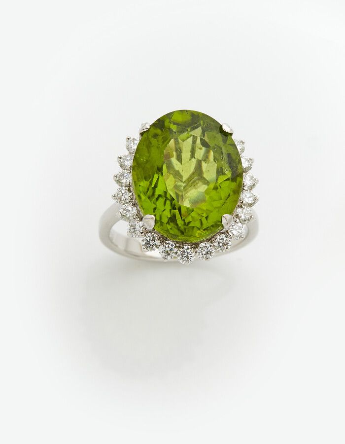 Null 一枚白金（750）"玛格丽特 "戒指，以椭圆形橄榄石为中心，周围镶嵌明亮式切割钻石。

橄榄石的重量：约12克拉。

手指：53。毛重：7.6克。