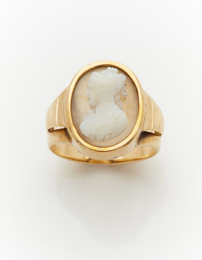 Null 黄金戒指(750)，上面有一个灰色玛瑙的椭圆形浮雕，代表一个女人的轮廓（有裂痕）。

手指：54。毛重：7.9克。