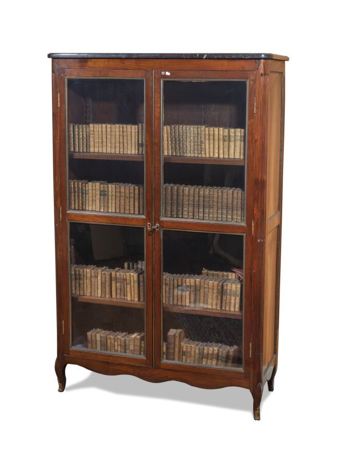 Null 桃花心木贴面或着色的木质书柜；长方形，它有两个玻璃门；带弧形凹槽的立柱；小凸脚。 18世纪（修改）。 黑色大理石顶部（断裂）。 高：156 - 宽：1&hellip;
