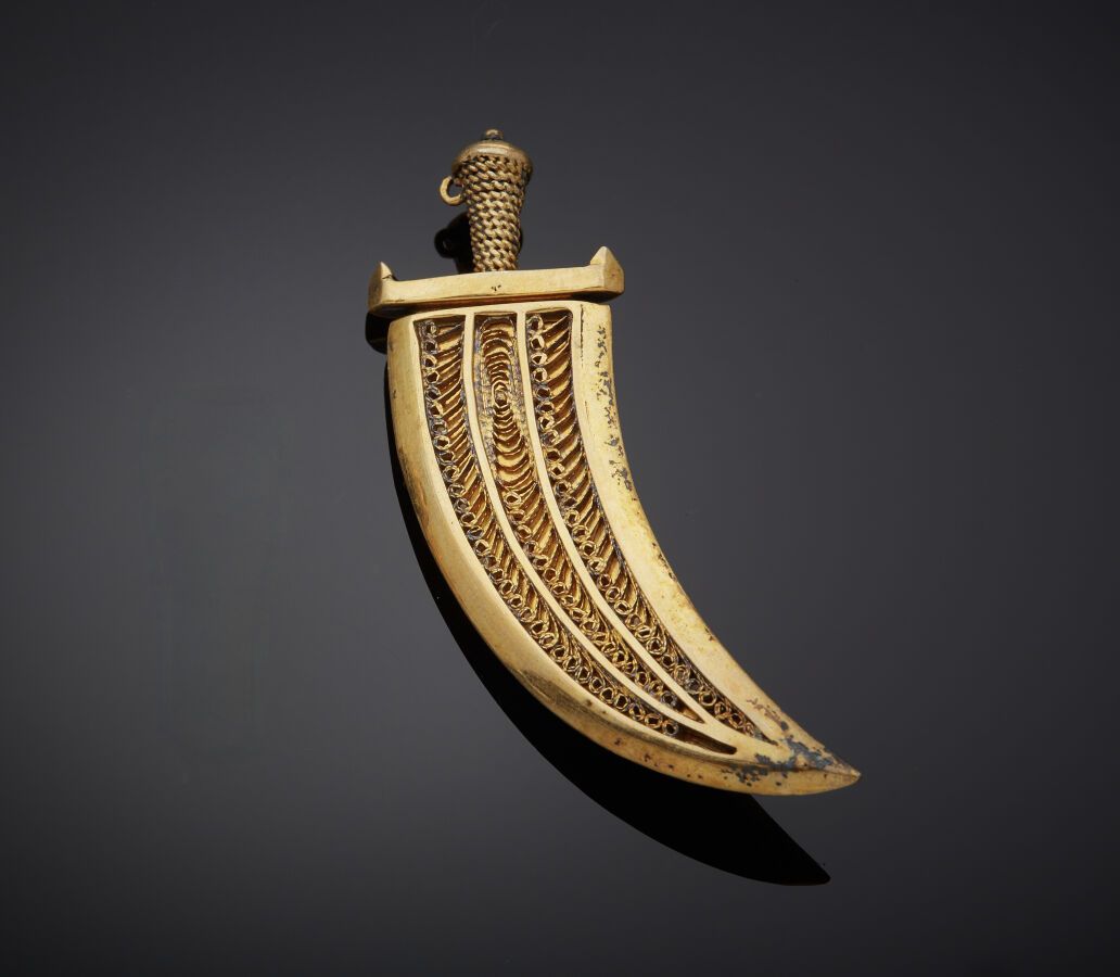 Null 
一枚镀金（最小800‰）的 "匕首 "别针，刀鞘和刀柄上有花纹。普通的金色刀片。有氧化的痕迹。埃及的工作。




长度：6.8厘米。重量：16,2&hellip;
