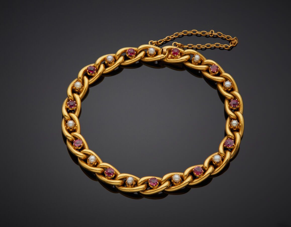 Null 一条黄金(750‰)路边链手镯，上面镶嵌着11颗红宝石，与11颗小珍珠交替使用（未测试）。安全链。

长度：17厘米左右。 毛重：12.4克。