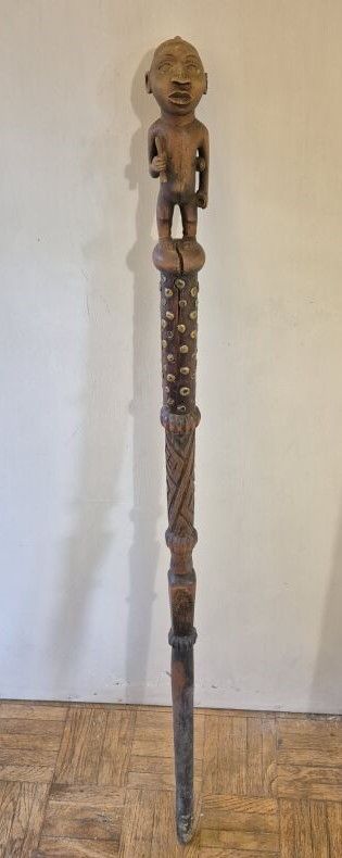 Null 手杖顶端有一个手持杵、臼和瓶的人物。
木质，有浅色铜锈。
高度：112 厘米。
产地：刚果共和国。
