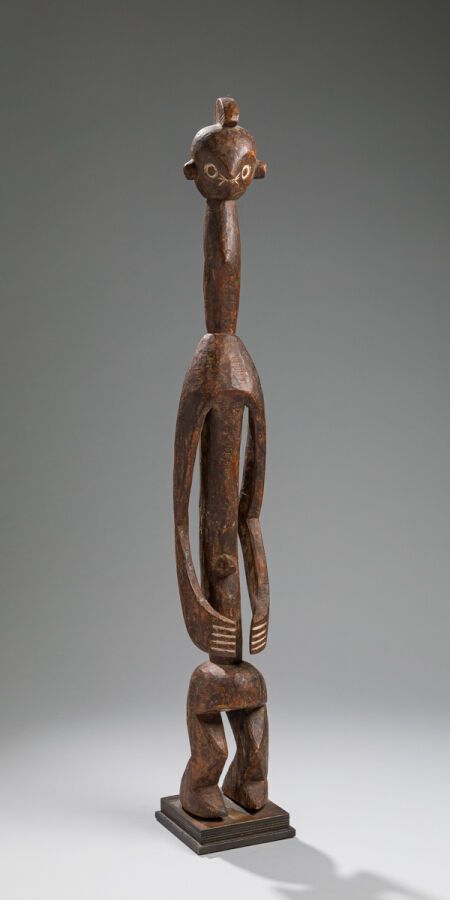 Null 拟人化的 Iagalagana 雕像，双腿微曲，站立着。双臂环绕身体。长颈支撑着卵形的头部，面部有一双用白色染料强化的圆形眼睛。头饰上有纹饰。
木质，&hellip;