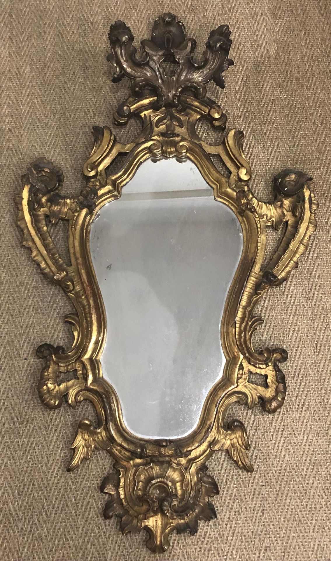 Null A gilded wood mirror with a contoured frame decorated with wavelets, bat wi&hellip;