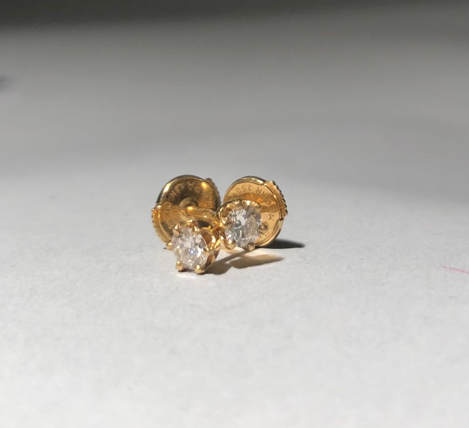 Null 一对18K(750)黄金耳钉，镶有一颗现代切割的小钻石。
毛重：1.10克。
