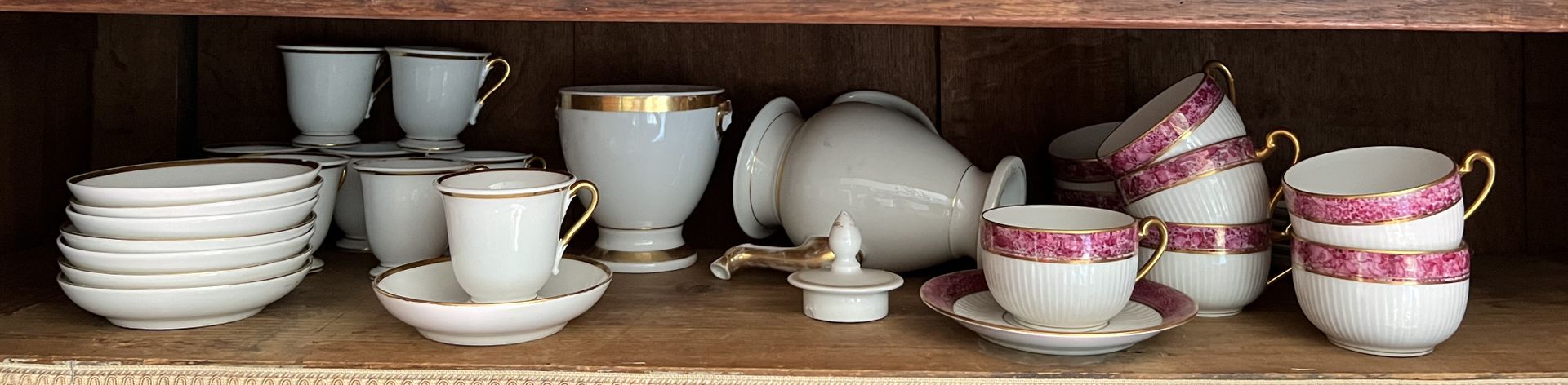 Null 
一套白瓷茶具，包括七个杯子和五个茶碟，唇部有粉红色大理石装饰和金色亮点。利摩日。 附有一个白色和金色的瓷器咖啡套装。 失序、磨损、事故。