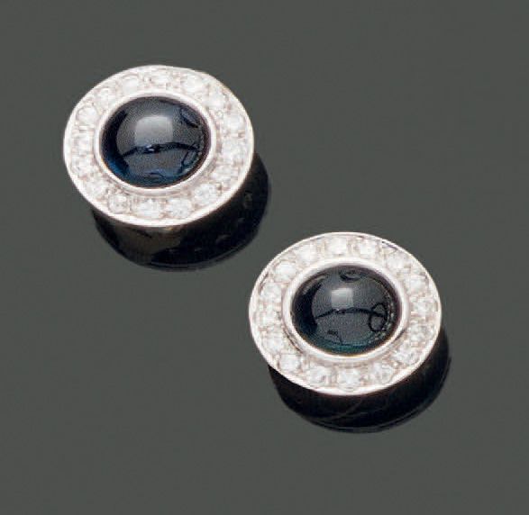 Null 一对18K(750)黄金和白金耳夹，每个耳夹都在圆形的钻石镶嵌中镶嵌了一颗凸圆形的蓝宝石。夹子系统。毛重：8.72克。