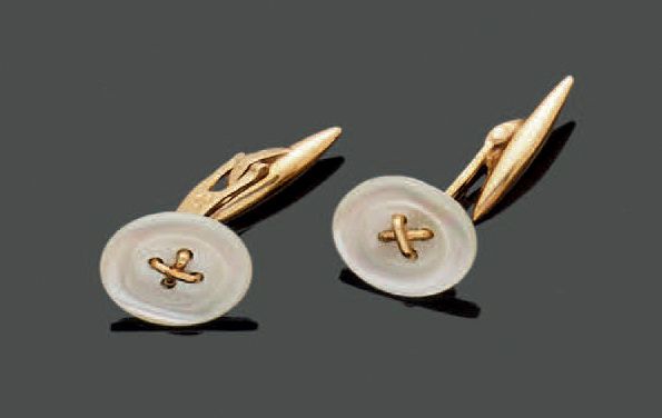 Null 一对18K(750)黄金袖扣，珍珠母盘中心有一个交叉缝制的模拟缝制的按钮，旋转的橄榄形扣子。毛重：6.55克。