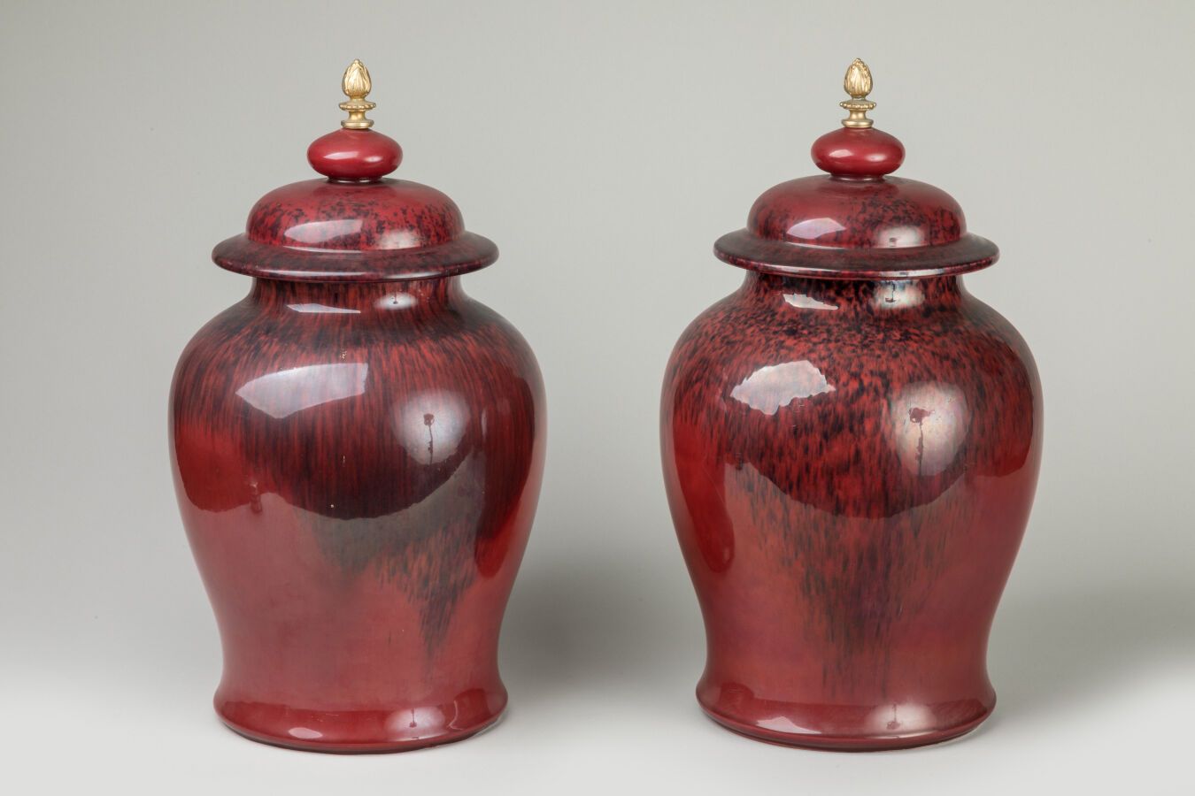 Null 塞夫勒 Paul MILLET（1870-1950 年）。一对有盖牛血红珐琅陶瓷大花瓶，青铜把手，塞夫勒法国制造标记。高 44 厘米。 
盖内有轻微烧&hellip;
