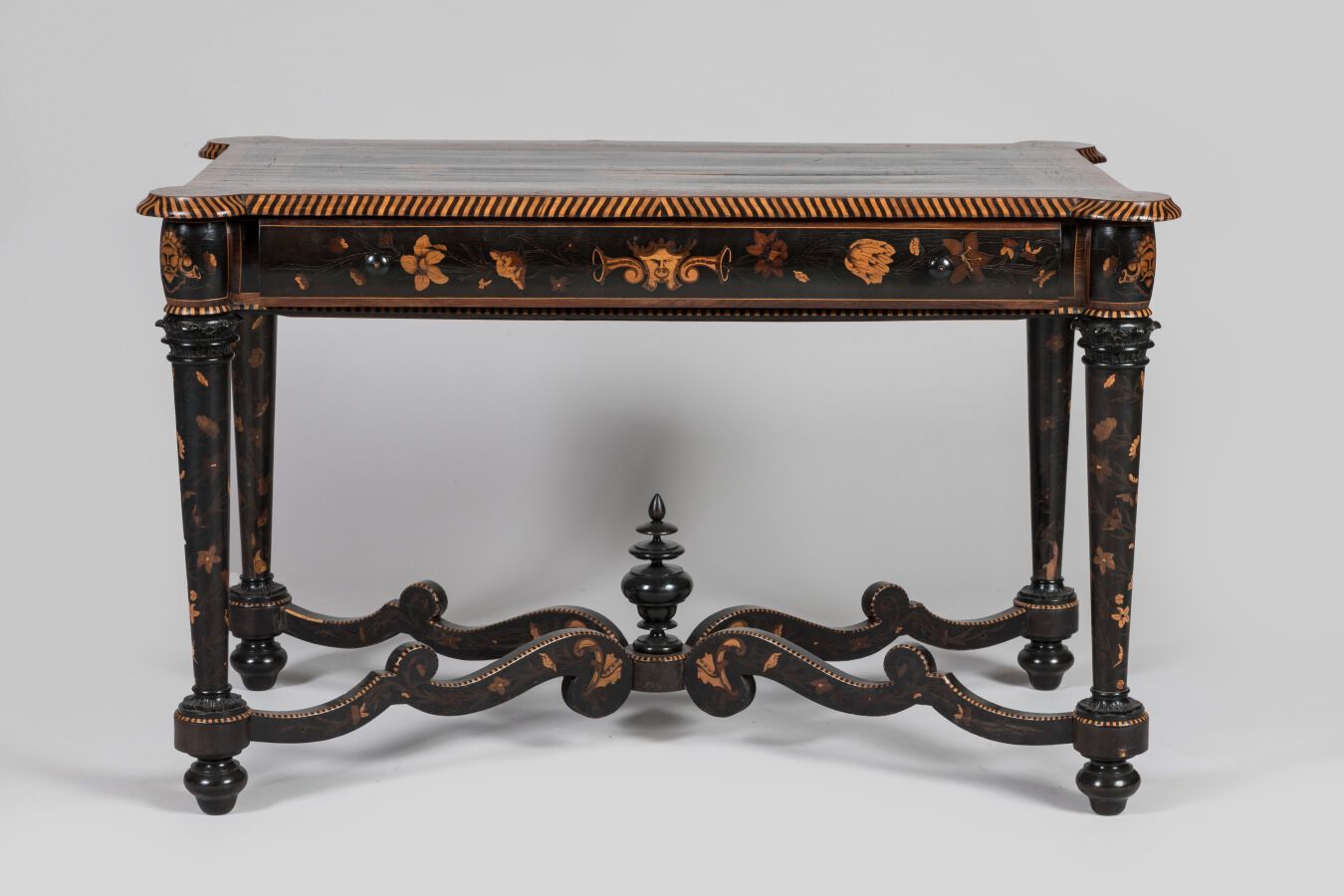 Null 发黑的木质书桌，镶嵌花篮和叶子装饰，前面有一个抽屉，桌腿由支架连接。意大利作品，19 世纪。 
尺寸：78.5 x 125 x 78 厘米
事故和修复