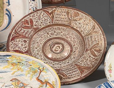 Espagne 
Hispano-Moorish陶器盘子，圆形，带脐带，翼上塑有花卉图案，装饰有铜质光泽的半 "punta de clavos"，风格化的花朵和&hellip;