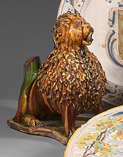 Italie ? 
陶器元件，代表一只后腿坐着的狮子，长方形的轮廓底座上，有赭石和绿色的装饰
18世纪（事故和缺失，碎片和划痕）
H : 30 cm