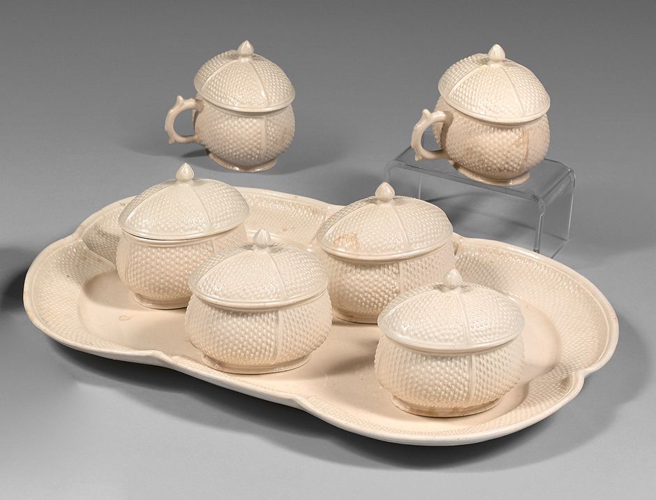 TERRE DE LORRAINE 六个有盖的果汁罐及其长方形展示架，为上等陶器，米色的单色背景上有浅浮雕的 "米粒 "图案装饰。18世纪。
长（托盘）：31.&hellip;