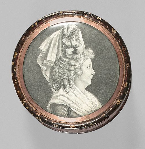 Null 圆形玳瑁盒，部分仿砂金石绘画，镶嵌小金粒，两面装饰有一男一女的肖像，以绒球为中心。略有磨损。18世纪晚期。
D : 6,4 - H : 2,5 cm