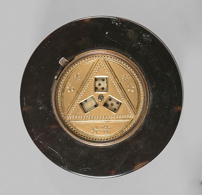 Null 斑驳的玳瑁色圆盒，盒盖上有一个罕见的镀金青铜的骰子游戏系统，原来有一个推杆可以转动三个骰子（系统损坏）。一个裂缝。
19世纪初的法国作品。
D : 8&hellip;