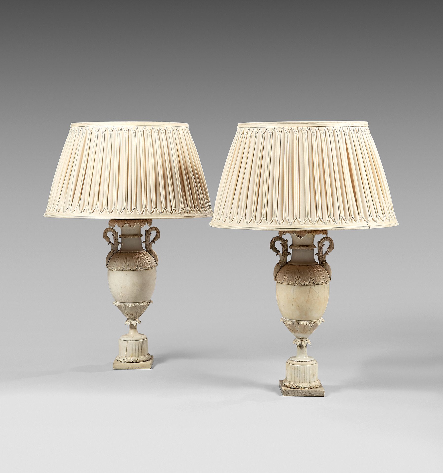 Null A pair of lamps formed by simulated vases in moulded and carved alabaster; &hellip;